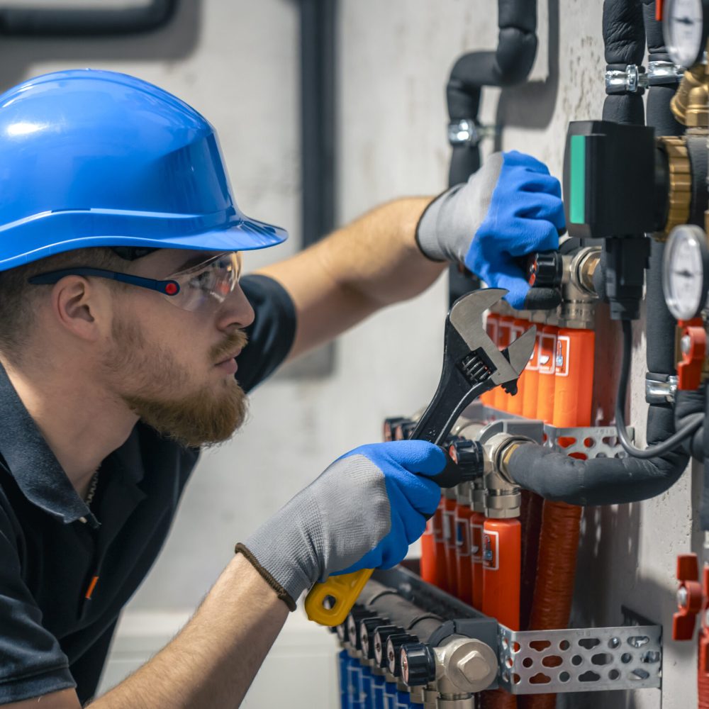 Adjusting heating valves in a residential building. A plumbing and heating technician works.